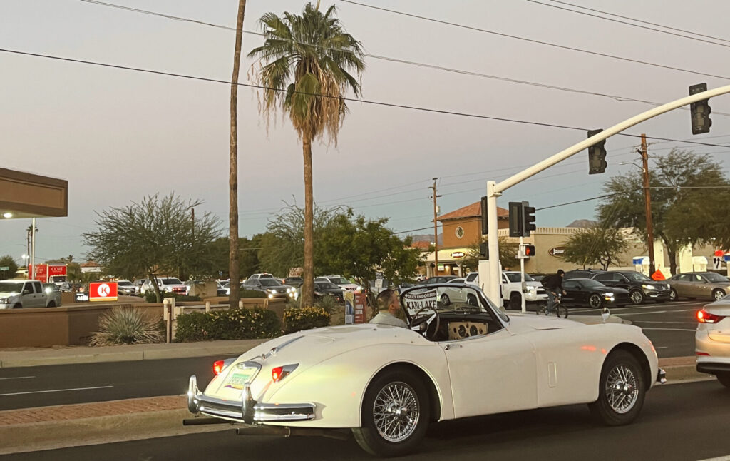 car driving past traffic lights during sunset